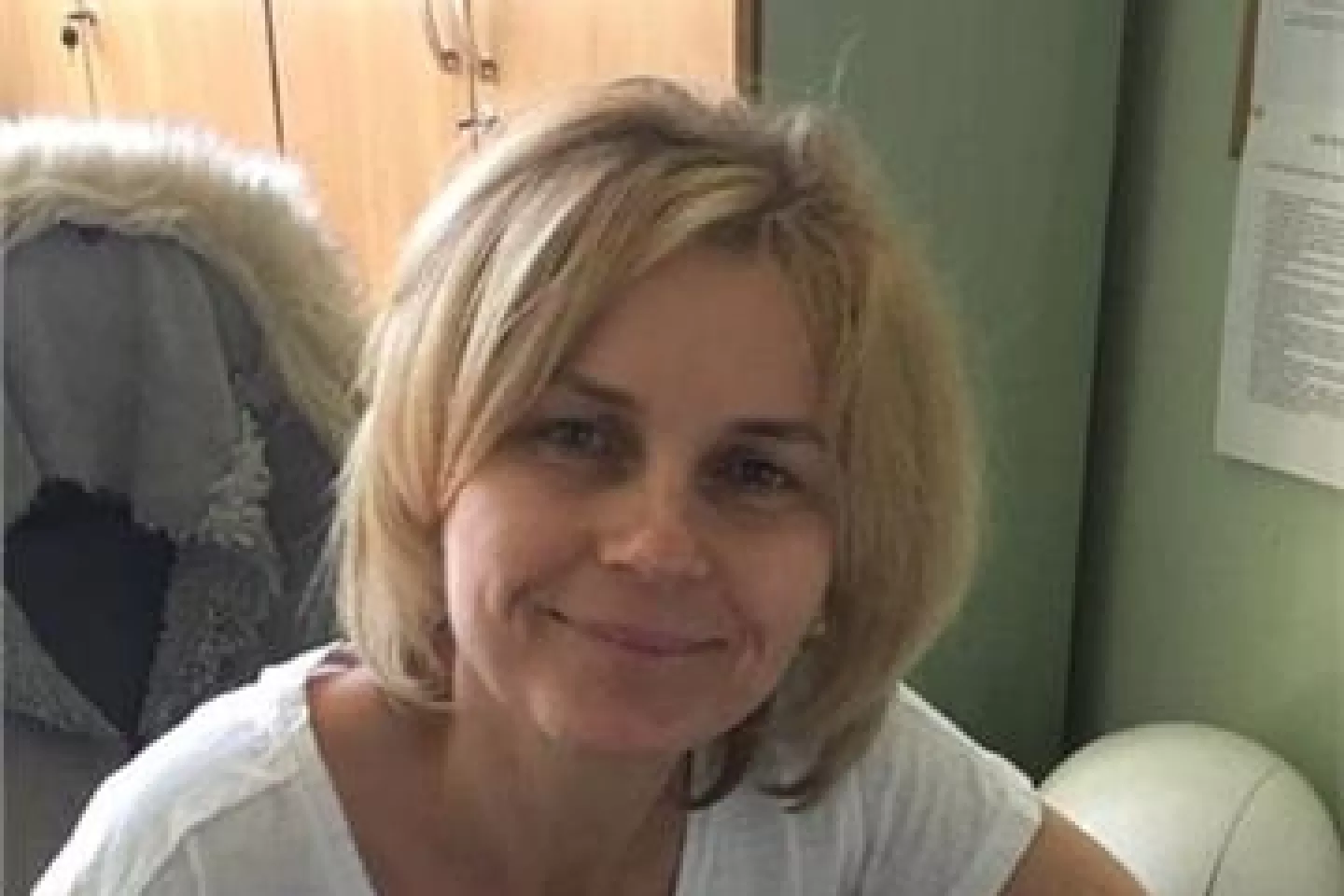 Kobieta w fotelu na tle szafy