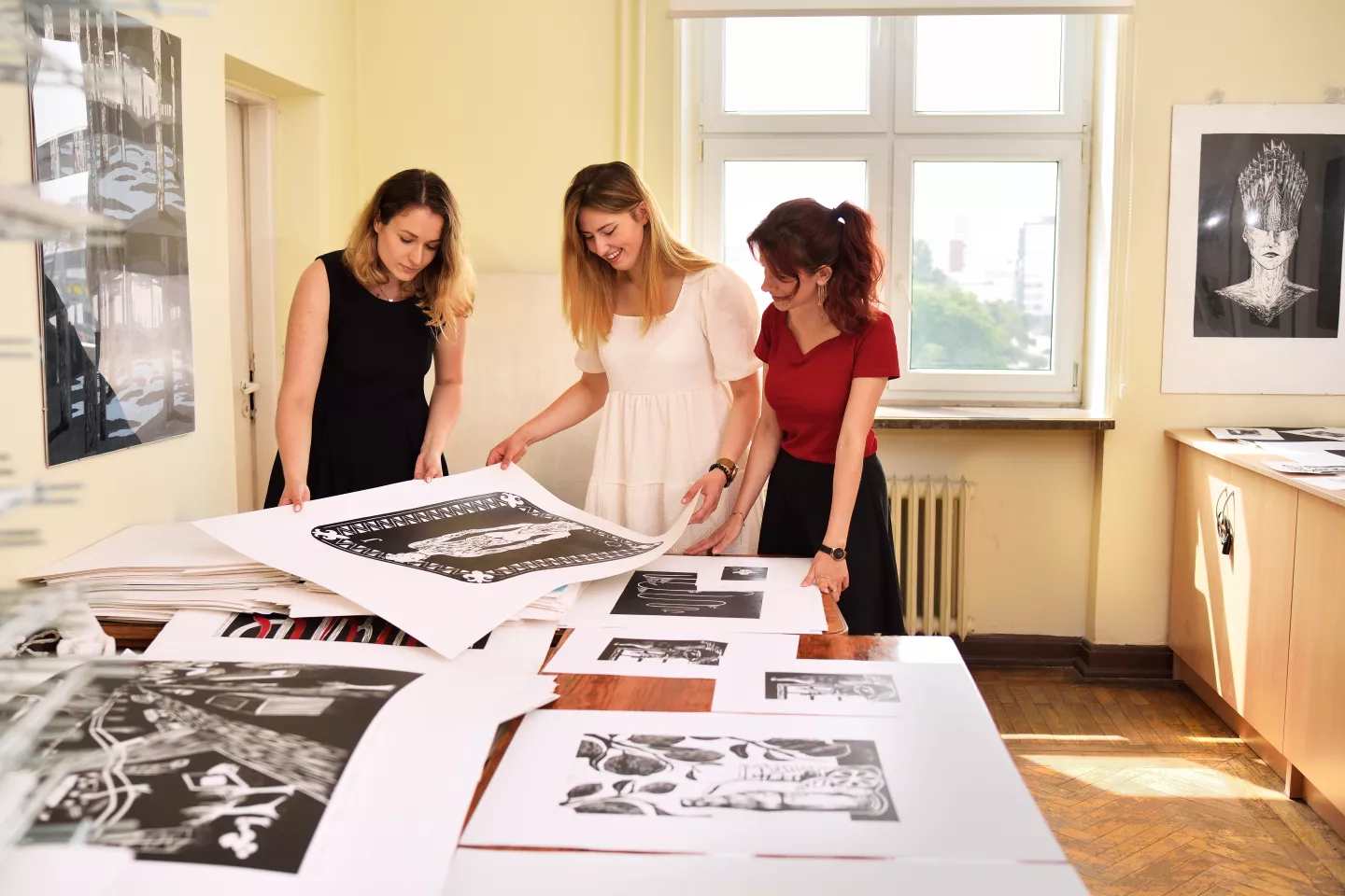 Studenci wzornictwa oglądają prace. 