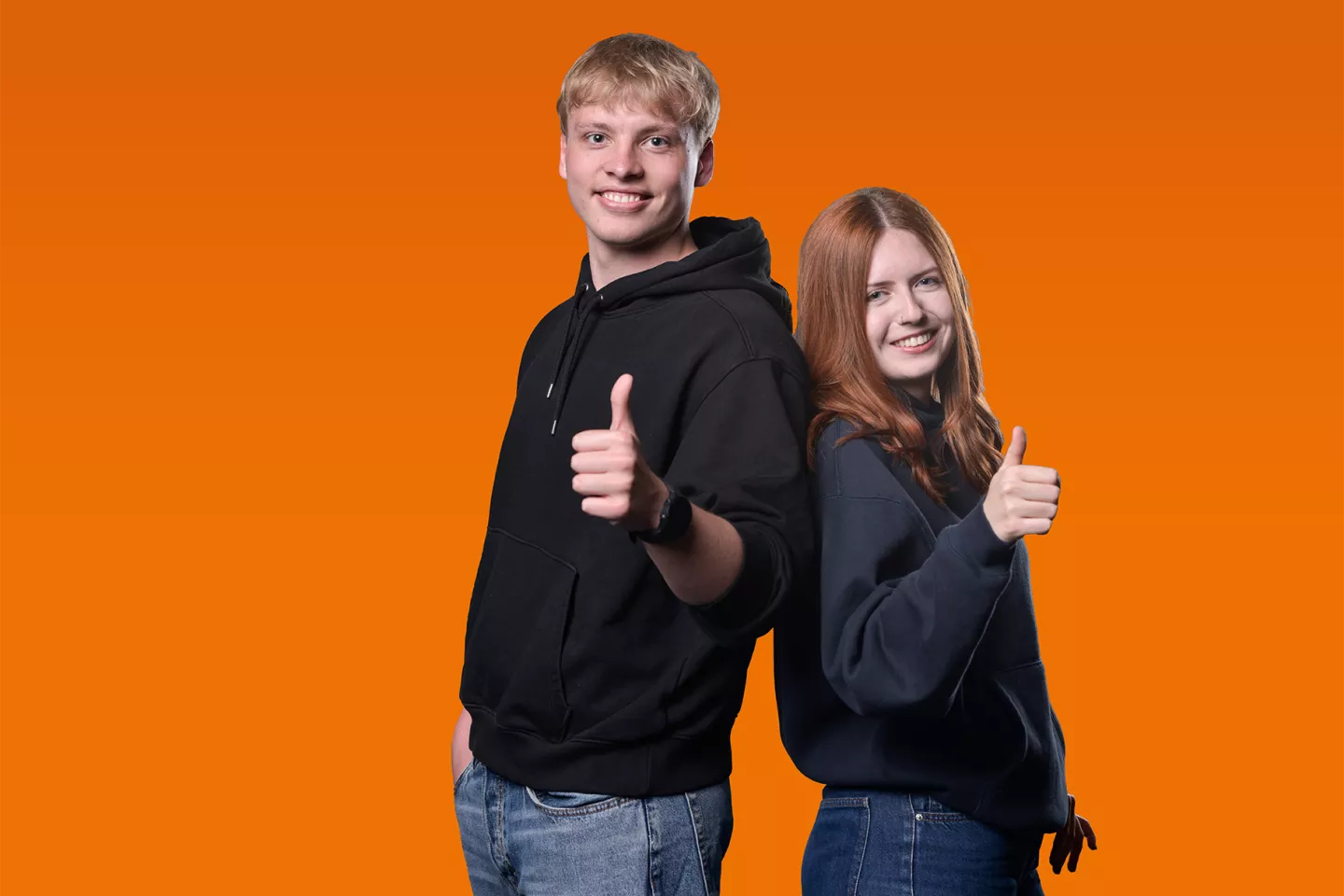 Studenci pokazują znak ok na pomarańczowym tle.