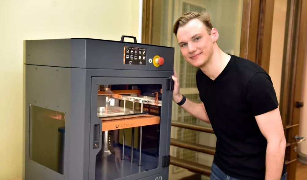 Mężczyzna stoi przy urządzeniu w laboratorium. 