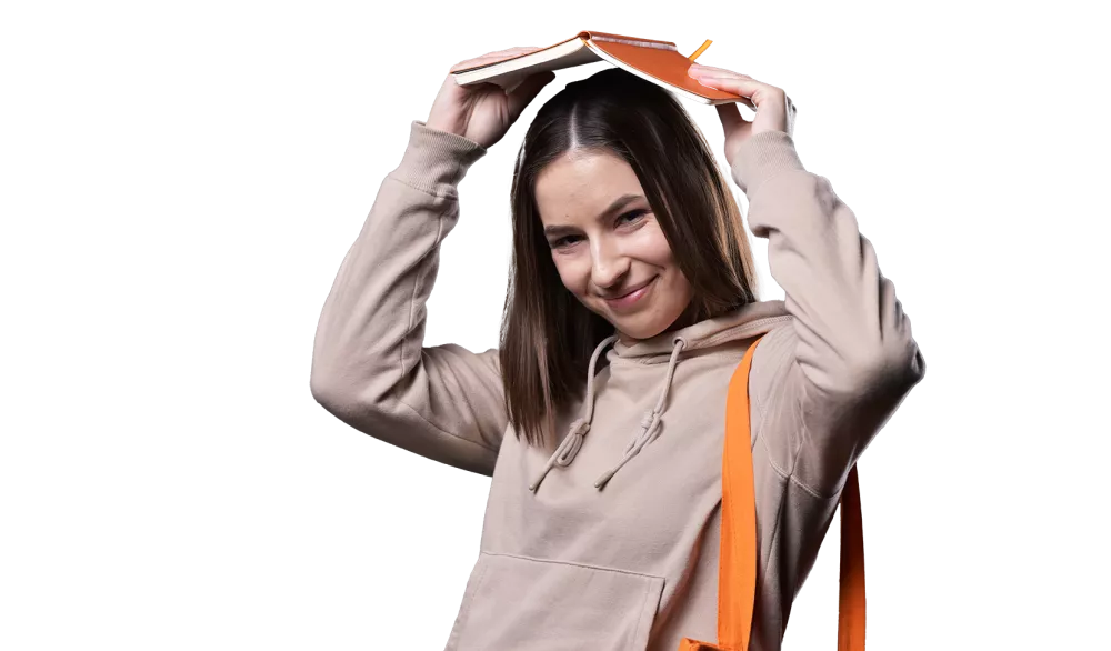 Studentka trzyma otwarty zeszyt nad głową.