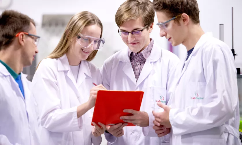 Studenci rozmawiają w laboratorium.