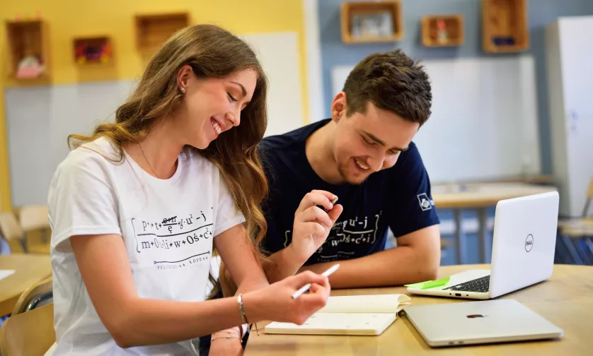 Studenci rozmawiają przy stole w sali kreatywnego myślenia.