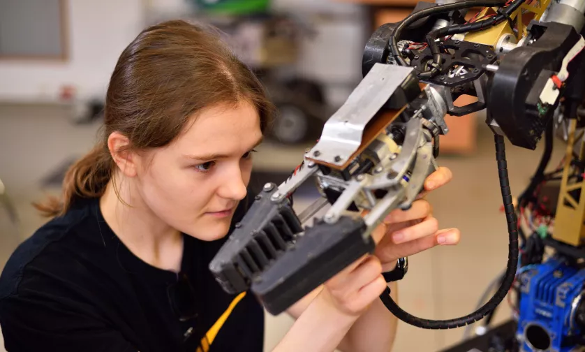 Studentka z chwytakiem przy robocie.