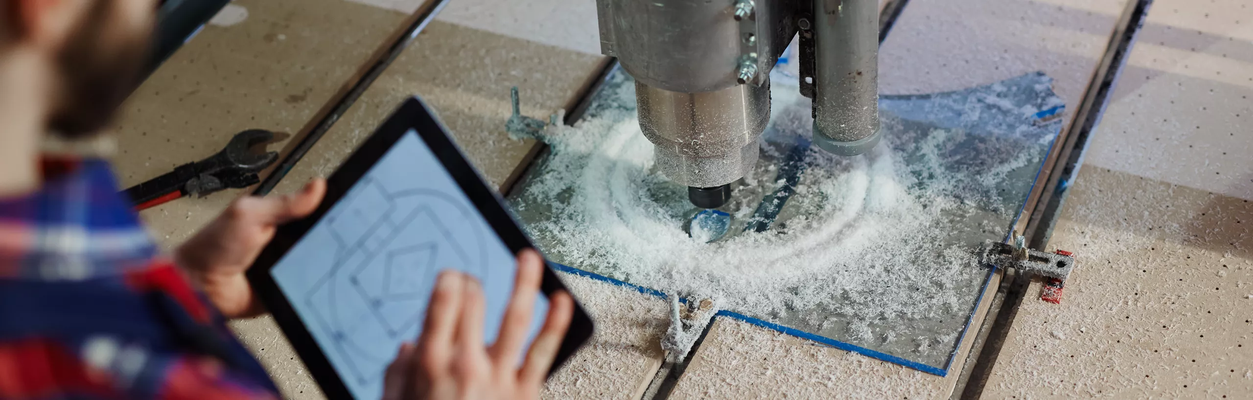 Inżynier trzyma tablet w ręce i pracuje przy urządzeniu.